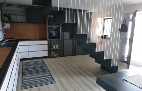 vista desde el lateral de las escaleras de acceso al piso superior, se puede ver también la cocina completa