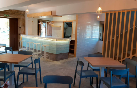 mostrador y zona de servir comidas, se ven varias mesas y sillas