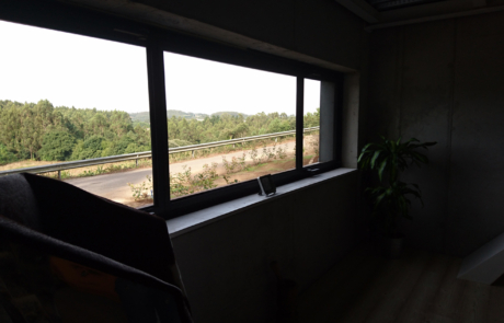vistas desde el interior de una habitación, se ve la carretera y zona boscosa al fondo