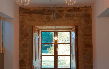 mesa para comer y cuatro sillas al fondo una ventana abierta