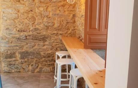 pequeño mostrador con taburetes debajo de una ventana