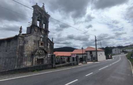 fachada exterior de un rectoral en medio de una carretera, el cielo está muy nuboso