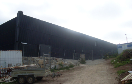 fachada en negro del edificio de una piscina en obras