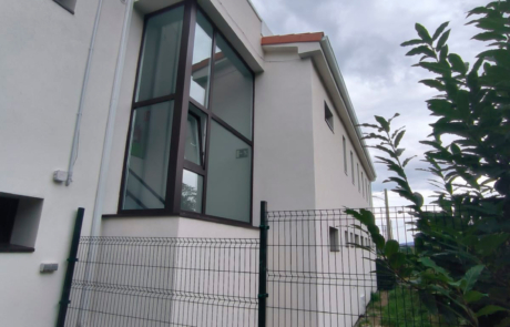 fachada de una cada con una zona acristalada en medio