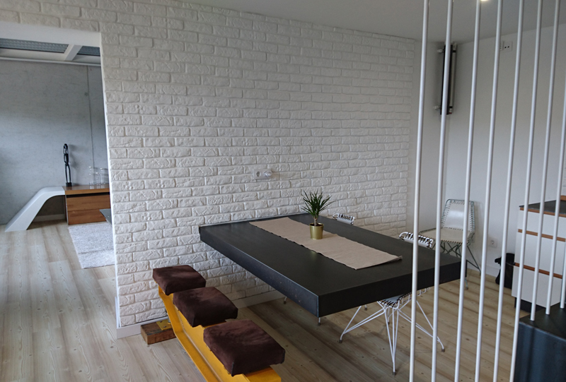 escaleras de subida al piso superior y se ve una mesa en color negro grande de comedor